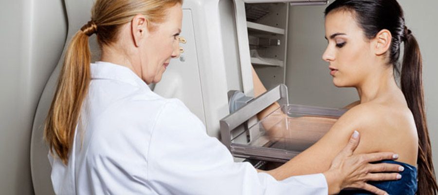 Mulher realizando exame de mamografia