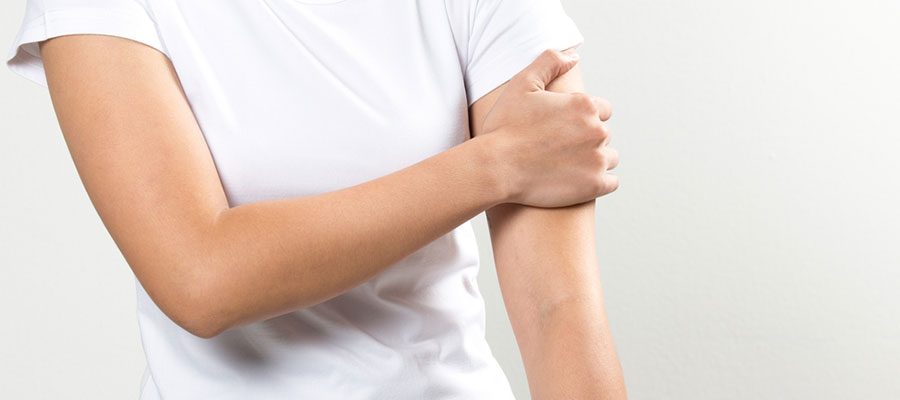 Mulher sente dor no braco por linfedema após câncer de mama