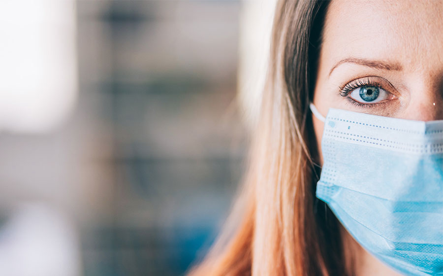 Mulher utilizando máscara para proteção contra o vírus