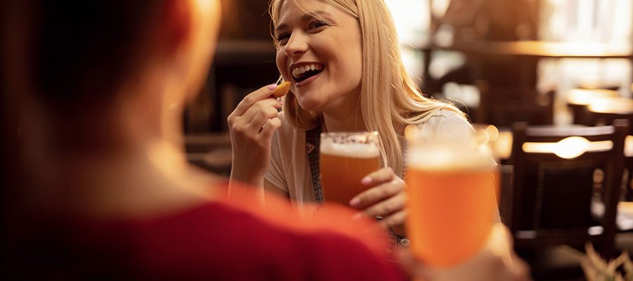 Mulher em pub bebendo cerveja