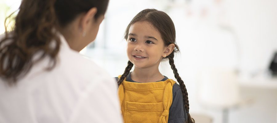 Criança no consultório recebendo boas notícias de médica