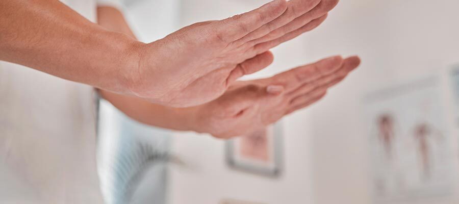 Mão aplicando reiki, uma técnica para amenizar câncer