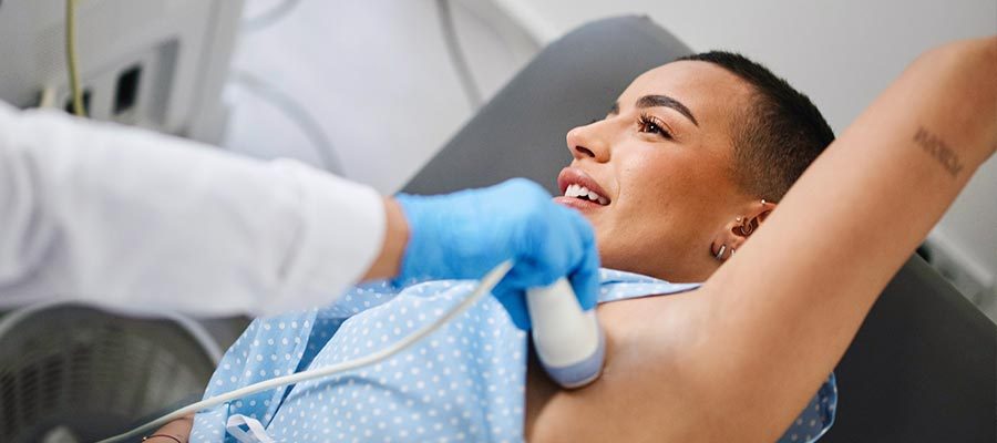 Mulher jovem fazendo um ultrassom na mama